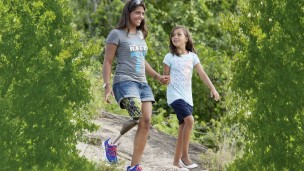 Karlianny walks downhill with her daughter